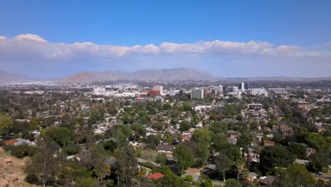 Sun-kissed-Riverside,-California,-under-clear-skies-and-striking-static-clouds,-beautifully-captured-in-a-forward-moving-drone-shot