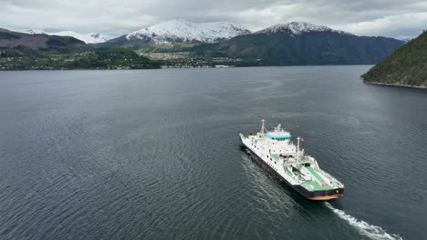 Ferry-to-Stranda-in-More-and-Romsdal-Norway---Ferry-named-Volda-is-underway-with-Stranda-town-seen-in-background-below-snow-capped-mountain