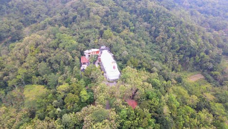 Chicken-Church-surrounded-by-forest-landscape-in-Indonesia,-aerial-orbit-view