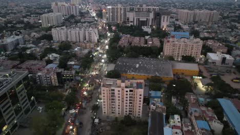 The-theater,-mall,-crowded-streets,-apartment-buildings,-and-metro-rail-construction-are-all-visible-in-an-evening-aerial-view-of-Chennai-City's-congested-Vadapalani-Signal-neighborhood