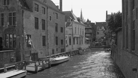 Tourists-riding-boats-on-the-canal-in-the-city-of-Bruges,-considered-one-of-the-most-beautiful-in-Europe