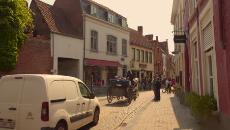 Tourists-riding-a-horse-drawn-carriage-in-the-city-of-Bruges,-considered-one-of-the-most-beautiful-in-Europe