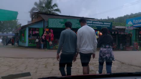 a-captivating-view-from-inside-a-car,-observing-people-slowly-walking-past-in-front-of-the-vehicle