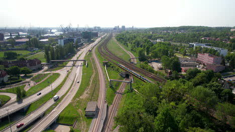 Train-on-railway-next-to-highway-in-Gdansk,-Poland