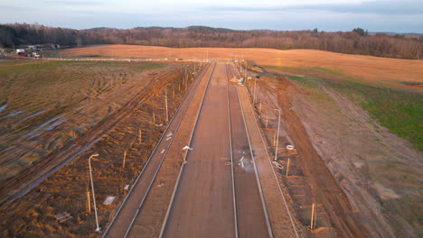 Aerial-forward-flight-over-road-building-site-in-Poland-during-golden-sunset-in-rural-area