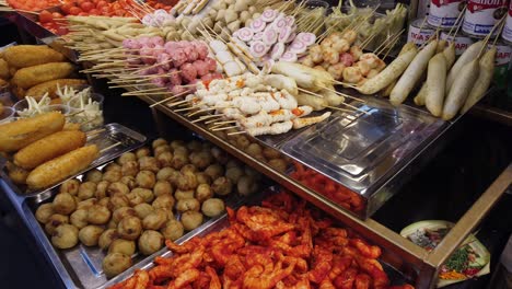 Traditional-Indonesian-Spicy-and-Fried-Food-Displayed-at-Street-Market,-Meatballs-Corn-and-Seafood