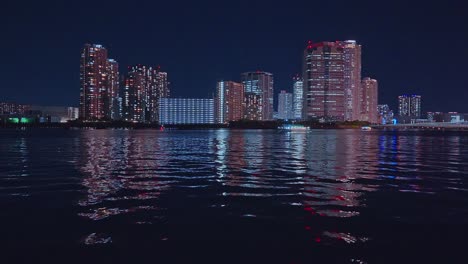 Night-light-Tokyo,-Tsukuda,-Toyosu-skyscrapers-and-bridge-the-Sumida-River-Yakatabune,-pleasure-boat