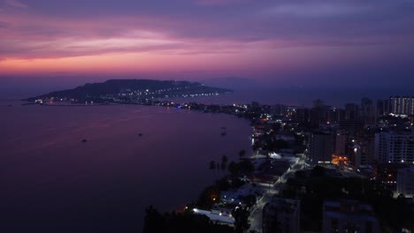 Aerial-view-at-sunset-with-a-purple-tone-of-part-of-the-city-of-Lecheria-with-El-Morro-hill,-located-in-the-north-of-Anzoategui-state,-Venezuela