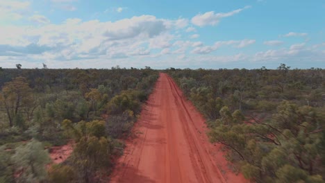 Drone-shot,-A-deserted-desert-track-with-bright-red-soil-in-the-Australian-outback