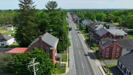 A-drone-truck-shot-over-a-street-over-red-brick-buildings-in-an-American-town