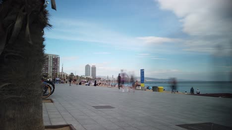 Menschen-Gehen-Am-Strand-Von-Barcelona-Spazieren,-Barcelona,-Spanien,-Zeitrafferaufnahme,-Meer,-Skyline-Im-Sommer