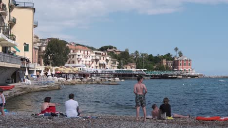 Late-afternoon-in-summer,-Italian-riviera-near-Genova,-town-of-Rapallo-and-people-on-the-beach