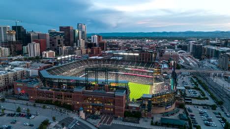 Drone-twilight-hyperlapse-of-Coors-Field,-live-baseball-game-and-Denver-skyline