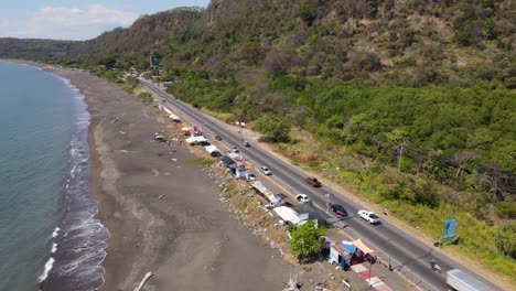 Aerial-drone-view-flying-away-from-Port-Caldera's-highway-traffic,-Puntarenas,-Costa-Rica