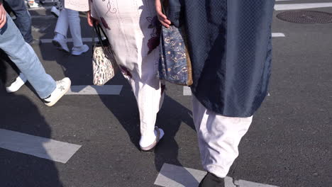 KYOTO,-JAPAN---April-3,-2023:-Close-up-of-people's-legs-walking-on-street-in-Japan