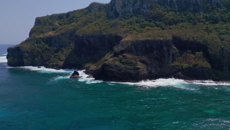 Drone-panorama-shot-of-green-mountain-and-crashing-waves-of-Caribbean-Sea-against-rocky-coastline---Blue-sky-and-sunlight-at-Cabo-Samana,-Dominican-Republic