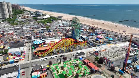 Un-Lento-Vuelo-Cinematográfico-Sobre-El-Parque-De-Atracciones-Coney-Island-En-La-Ciudad-De-Nueva-York-Con-La-Playa-De-Brighton-Y-El-Horizonte-De-La-Ciudad-Visible-Al-Fondo