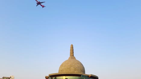 Buddha-Stupa-Mit-Vorbeifliegendem-Flugzeug-Und-Strahlend-Blauem-Himmel-Am-Morgen-Aus-Einem-Anderen-Blickwinkel.-Das-Video-Wurde-Am-15.-April-2022-Im-Buddha-Park-In-Patna,-Bihar,-Indien,-Aufgenommen