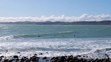Surfeando-En-Raglán,-Surfistas-Remando-Y-Esperando-Una-Ola-Para-Surfear,-Waikato,-Nueva-Zelanda-Aotearoa
