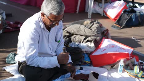 In-a-shop-on-the-road,-a-cobbler-is-making-sandals-out-of-leather-with-his-tools,-this-work-is-not-done-by-machine-but-by-hand