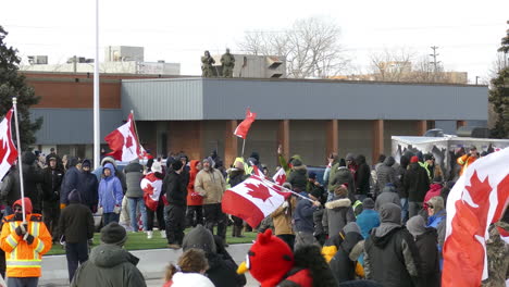 A-Freedom-Convoy-protest-in-Windsor,-Ontario-against-COVID-rules-is-controlled-by-army-and-police,-highlighting-civil-unrest-and-controversy