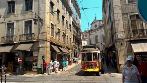 Establishing-slow-motion-of-passing-yellow-tram-on-road-in-Lisbon-City-Center-in-summer