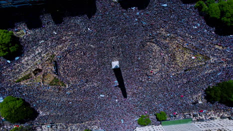 Infinite-spin-aerial-shot-of-obelisk-surrounded-by-Argentinian-football-soccer-fans-during-world-cup-final-in-Buenos-Aires