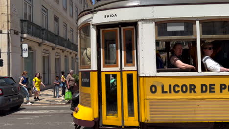 Zeitlupe-Der-Vorbeifahrenden-Berühmten-Gelben-Straßenbahn-In-Der-Innenstadt-Von-Lissabon-An-Einem-Sonnigen-Tag---Verkehr-Auf-Der-Straße-Mit-Vielen-Menschen-In-Der-Fußgängerzone
