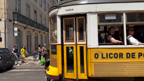 Establecer-Cámara-Lenta-Al-Pasar-El-Famoso-Tranvía-Amarillo-En-El-Centro-De-Lisboa-Durante-El-Día-Soleado---Tráfico-En-La-Carretera-Con-Muchas-Personas-En-La-Zona-Peatonal