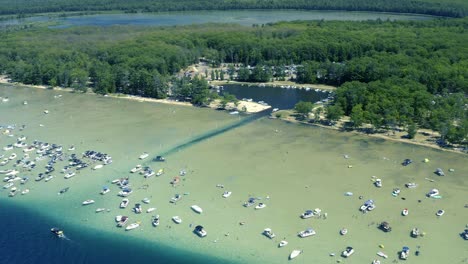 Aerial-Pan-Up-Shot-of-Lagoon-and-small-Lake-with-Boats-and-People-in-Shallow-Waters-of-a-Glacial-Lake-in-Michigan