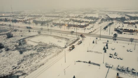 Aerial-tracking-view-of-snow-plows-and-tractors-clearing-road-in-Toronto