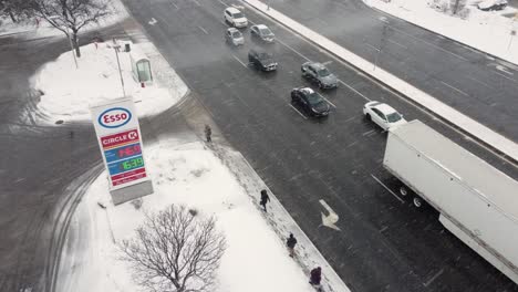 Los-Peatones-Se-Refugian-De-Una-Tormenta-De-Nieve-En-La-Parada-De-Autobús-Junto-A-La-Gasolinera