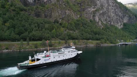 Toma-Lateral-Del-Ferry-Fjord1-Navegando-Por-El-Fiordo-De-Geiranger-Acercándose-Al-Muelle