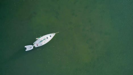 Aerial-Shot-of-Anchored-Sailboat-in-Bay