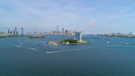 Aerial-Shot-of-Boats-in-Front-of-Statue-of-Liberty-and-the-New-York-City-Skyline
