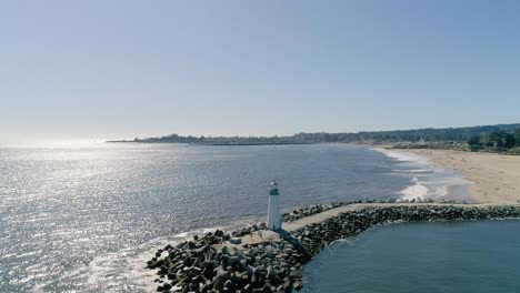 Leuchtturm-Am-Pier-Im-Sonnenlicht-Glitzerndes-Wasser-An-Der-Pazifikküste