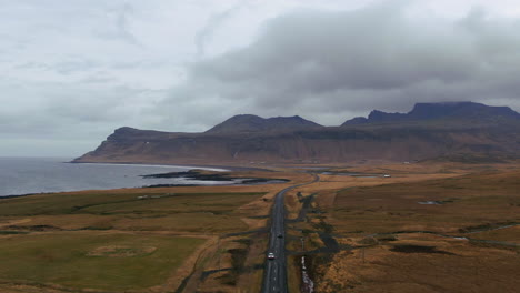 Mountains,-valley-and-coast,-with-roadways-lightly-traveled-on-an-overcast-day-in-Iceland