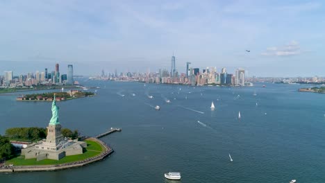 Rückfahrkamera-Aus-Der-Luft-Der-Freiheitsstatue-Und-Der-Skyline-Von-New-York-Mit-Booten-Und-Hubschraubervorbeiflug