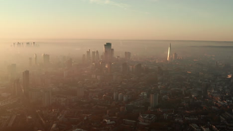 Tight-rising-establishing-aerial-shot-of-London-skyscrapers-on-a-foggy-morning