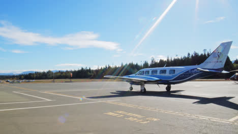 Una-Toma-De-Un-Jet-Privado-Y-Un-Helicóptero-Parados-En-Un-Pequeño-Aeropuerto-Uno-Al-Lado-Del-Otro-En-Un-Día-Soleado-En-Columbia-Británica,-Canadá