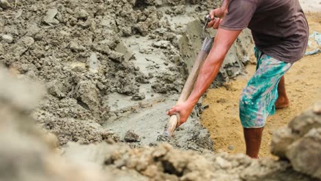 Closeup-of-worker-man-using-shovel-to-remove-clay-earth-from-dirt-pile