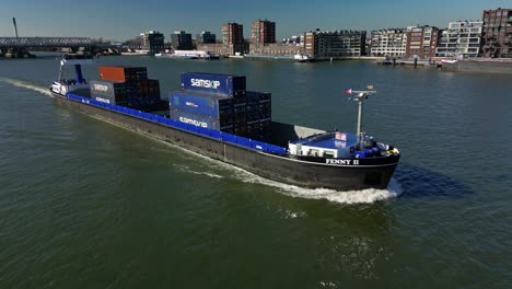 Aerial-view-of-the-cargo-transport-ship-"Fenny-2"-navigating-through-the-canal-in-Dordrecht,-The-Netherlands