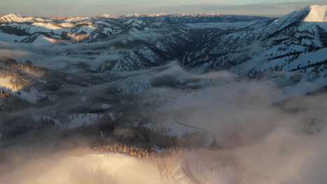 Teton-Pass-Malerische-Route-An-Sonnigen-Wintermorgen,-Luftaufnahme-Der-Straße,-Wolken-Und-Weiße-Landschaft