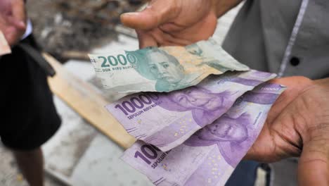 Dirty-and-crumpled-old-rupiah-banknotes-in-hand