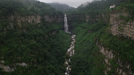 Idyllischer-Hoher-Wasserfall-Im-Amazonas-Dschungel-Regenwald,-Luftaufnahme,-Neigung-Nach-Unten-Zum-Flusslauf