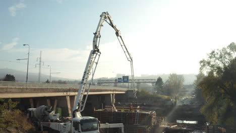 Großer,-Auf-Einem-LKW-Montierter-Betonpumpenarm,-Der-An-Einer-Baggerstelle-Auf-Der-Autobahn-Arbeitet