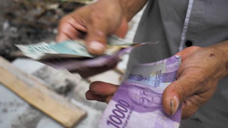Altes-Schmutziges-Rupiah-Papiergeld-Aus-Indonesien-Wird-In-Händen-Gezählt,-Die-Indonesischen-Währungsrupiahs