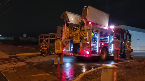 Firefighters-load-up-fire-truck-and-pack-away-fire-hose-after-work