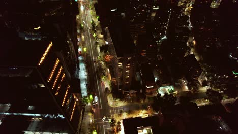 Aerial-orbit-shot-overhead-Las-Condes-at-night-with-cars-driving-through