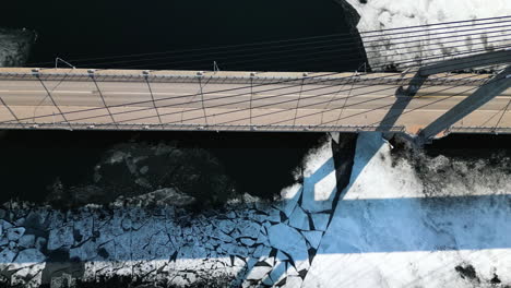 Von-Oben-Nach-Unten-Fliegende-Luftaufnahmen-Seitwärts-über-Eine-Hängebrücke-Im-Arktischen-Klima